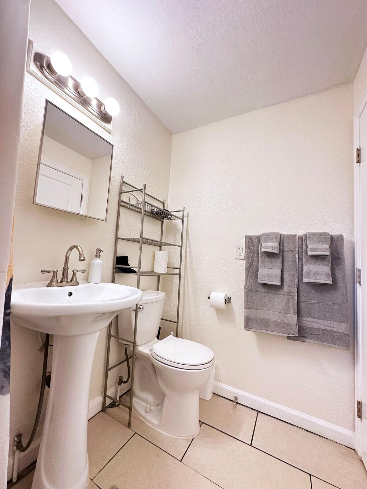Bathroom with towels, extra toilet paper, hair dryer, soap