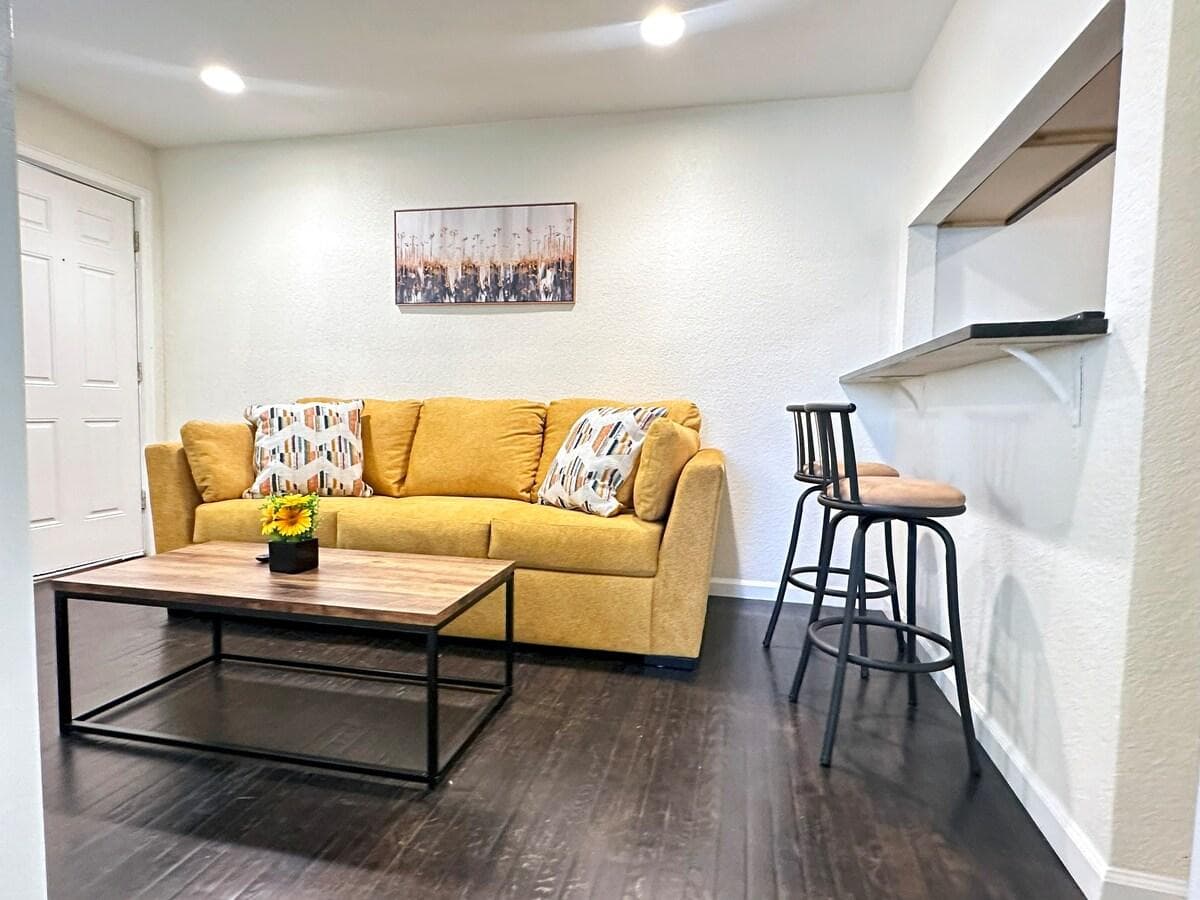Living room area with comfy couch and eating area with counter stools